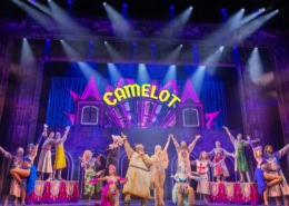 Full cast of Spamalot musical performing Camelot number on colorful stage with dancers and knights”
