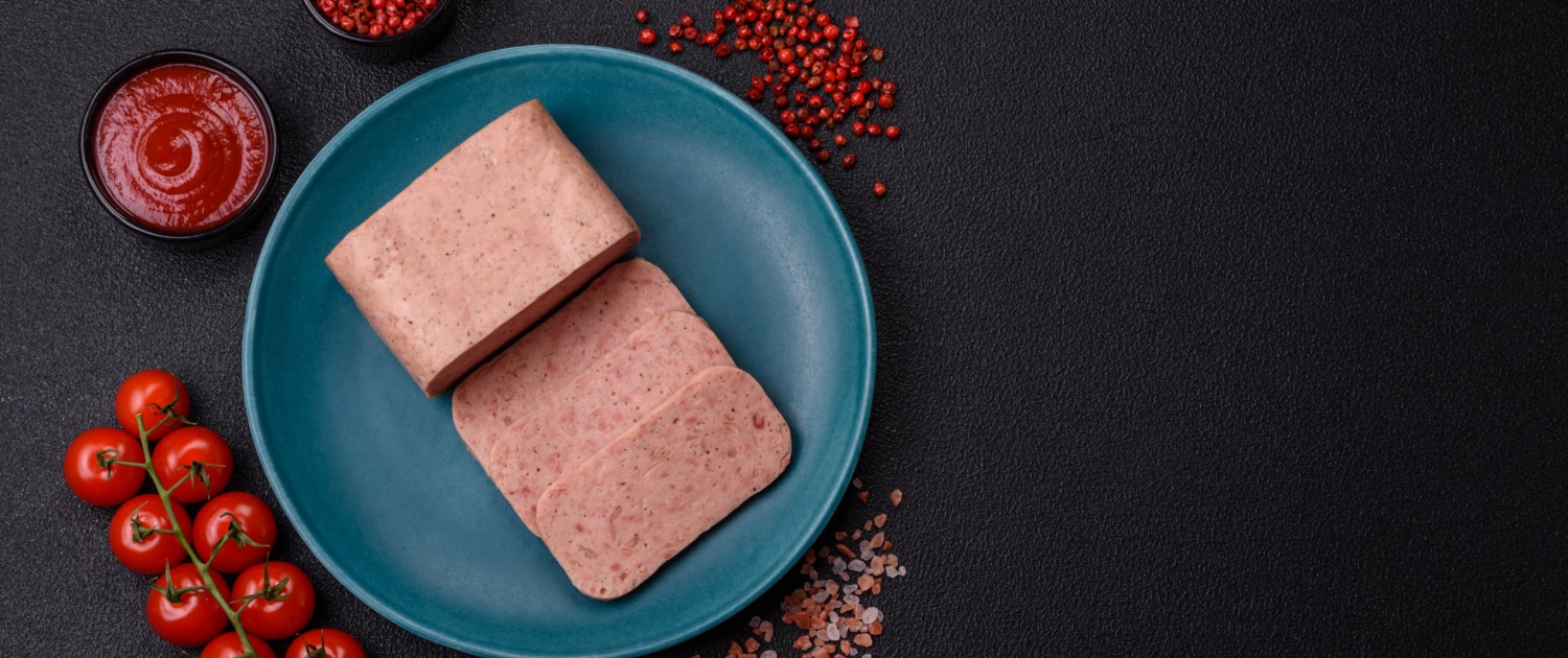Who among us has eaten SPAM®? Now, come on. Be honest. You can get a 12 ounce can of salty, spammy goodness for around $4. It comes in a variety of flavors — oven roasted turkey, hickory smoke, jalapeño, bacon, maple, hot and spicy, teriyaki, low sodium, lite, and good ol’ classic. That doesn’t even take into account the international flavors. South Korean sells Korean BBQ, Gochujang (Korean chili paste flavor), and Kimchi. Japan sells its own barbecue version. The Philippines sells a Tocino seasoned variety (sweet-cured Filipino breakfast pork) while Hawaii offers a Portuguese Sausage. By spam, there are even cheese, garlic, honey, chorizo and…wait for it…pumpkin spice varieties! How did this inexpensive canned meat go from laughingstock of aisle 6 to one of the most recognizable staples of high cuisine? It all began in the 1930s when Hormel Foods wanted to discover a use for pork shoulder, which was a cut of meat that was underperforming in the grocery store. The company developed a relatively simple recipe: pork, ham, salt, water, potato starch, sugar, and sodium nitrate (a preservative). Cooked inside the can, SPAM is a tasty shelf-stable, ready-to-eat meat that doesn’t have to be refrigerated. Unsurprisingly, when World War II broke out, the U.S. military delivered over 100 million pounds of this durable, portable, canned meat alternative overseas. Troops took it to Europe, the Pacific Islands, Japan, Korea, and elsewhere —¬ many of the places where it continues to be incredibly popular to this day. SPAM became a staple ingredient in many of the Pacific regions in such dishes as SPAM Musubi in Hawaii (grilled SPAM on rice wrapped with nori seaweed), Korea’s budae jjigae (army stew), and Spamsilog in the Philippines (SPAM, garlic fried rice, and eggs). But we in musical theatre like to think that the real catapult happened in the 1970s when Monty Python introduced SPAM into popular culture through its comedy sketch entitled “SPAM” for Monty Python’s Flying Circus, which was set in a restaurant where nearly every item contained SPAM. According to Wikipedia, the word “spam” was used in the sketch so repetitiously as to be intentionally annoying, ultimately leading to its adoption to describe unwanted emails. The comedy troupe didn’t stop there. In Monty Python and the Holy Grail, the Knights of the Round Table sing: We’re the knights of the Round Table, we dance whenever we’re able… We eat ham and jam and Spam a lot. According to Eric Idle, one of six members of Monty Python who later wrote the books and lyrics for Spamalot, the son, in fact, inspired the musical’s name. That it happens to be a play on Camelot becomes a fun pun for the show. Over the past 90 years, more than 9 billion cans of SPAM have been sold. In fact, SPAM is sold in 50 countries and 12.8 cans of SPAM products are eaten every second. Succumb to the pressure! Visit SPAM online for recipes, fun facts merch, and a museum. And if you don’t get your fill there, there’s always Monty Python’s Spamalot. 