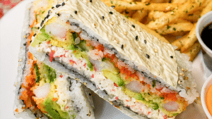 Sushi sandwich from Tora Sushi & Ramen at McGregor Square Food & Drink served with seasoned fries, dipping sauces, and a grain bowl.