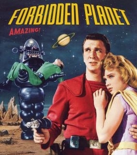Movie poster for Forbidden Planet. A person in a bright red futuristic uniform stands in the foreground holding a ray gun while another person in a light-colored outfit stands beside them. Behind them, a large robot carries an unconscious figure across a rocky alien landscape. A ringed planet appears in the night sky above, with the film title displayed in bold yellow and red text.